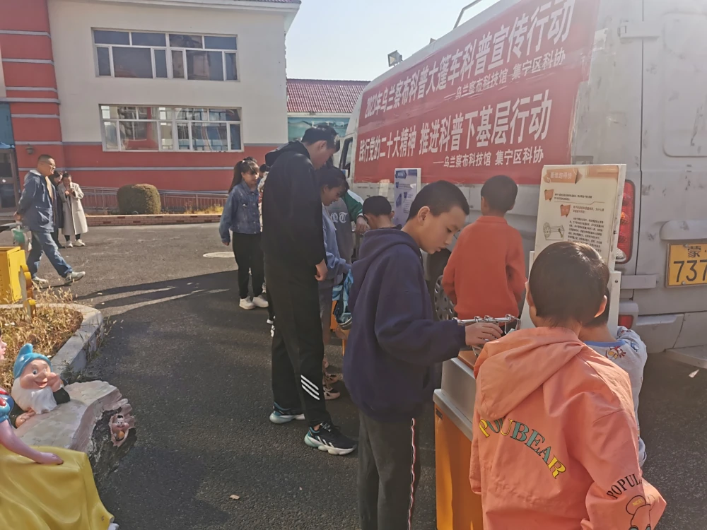 福利院的孩子动手操作大篷车车载展品